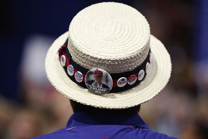 FILE - In this July 20, 2016 file photo, a delegate shows off support for Republican Presidential Candidate Donald Trump during the third day session of the Republican National Convention in Cleveland. The Republican National Committee is sharply restricting attendance on three of the four nights of its convention in Jacksonville, Florida, next month as coronavirus cases are spiking in the state. (AP Photo/Carolyn Kaster)