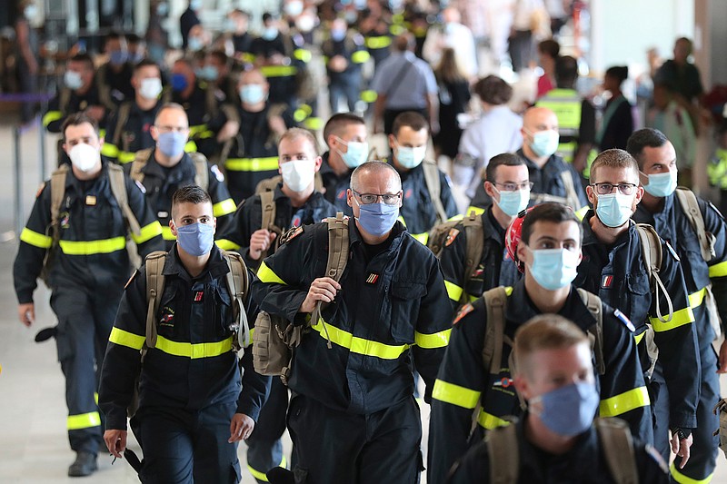 Members of the Securite Civile rescue organisation arrive at Charles de Gaulle airport, north of Paris, Wednesday, Aug.5, 2020. France is sending two planes to Lebanon on Wednesday with dozens of emergency workers, a mobile medical unit and 15 tons of aid. The aid is expected to arrive Wednesday afternoon and should allow for the treatment of some 500 blast victims, according to French President Emmanuel Macron's office. (AP Photo/Thibault Camus)