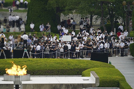 Visitors observe a minute of silence for the victims of the atomic bombing, at 8:15am, the time atomic bomb exploded over the city, at the Hiroshima Peace Memorial Park during the ceremony to mark the 75th anniversary of the bombing Thursday, Aug. 6, 2020, in Hiroshima, western Japan. (AP Photo/Eugene Hoshiko)