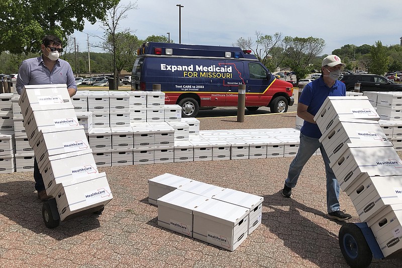 FILE - In this May 1, 2020, file photo, campaign workers David Woodruff, left, and Jason White, right, deliver boxes of initiative petitions signatures to the Missouri secretary of state's office in Jefferson City, Mo. (AP Photo/David A. Lieb, File)