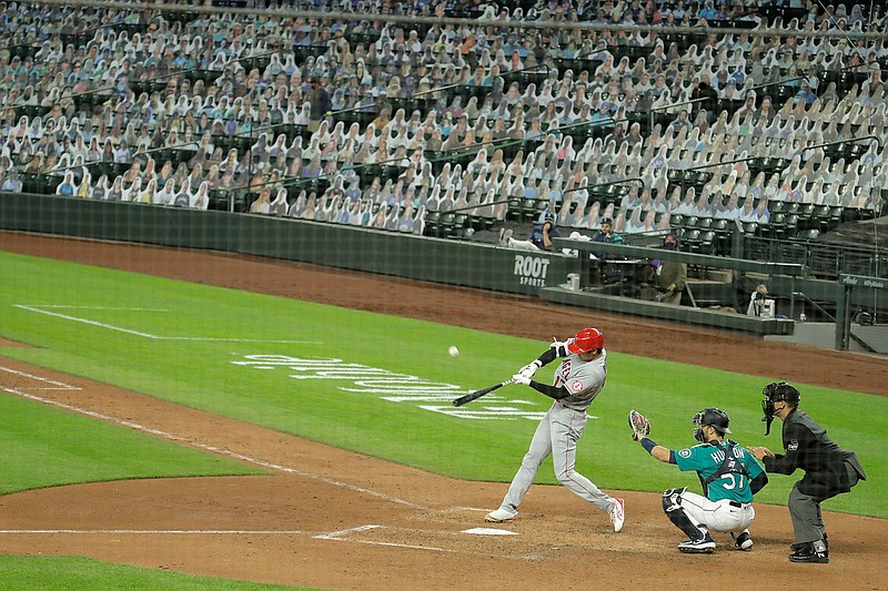 With photos of fans filling the seats at Safeco Field, Los Angeles Angels' Shohei Ohtani flies out to center field to end the top the seventh inning of a baseball game against the Seattle Mariners, Thursday, Aug. 6, 2020, in Seattle. (AP Photo/Ted S. Warren)