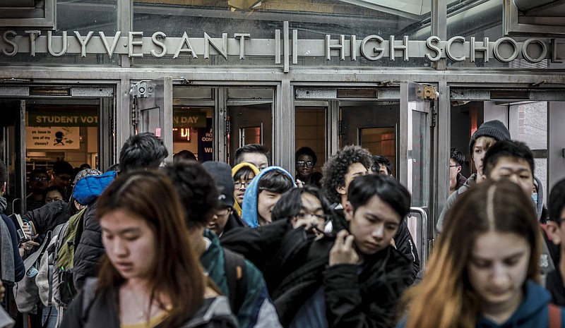 FILE - In this March 13, 2020, file photo, students at Stuyvesant High School leave after classes in New York. New York Gov. Andrew Cuomo said Friday, Aug. 7, 2020 that he would allow children statewide to return to classrooms for the start of the new school year, citing the state's success in battling the coronavirus pandemic. (AP Photo/Bebeto Matthews, File)