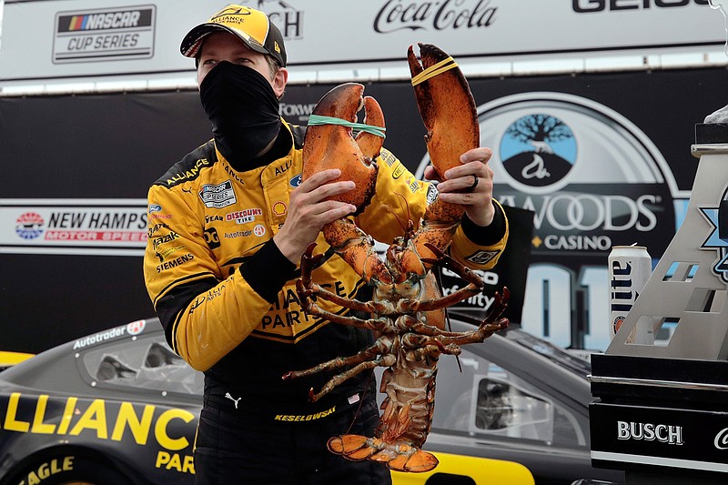 Driver Brad Keselowski holds a giant lobster to celebrate his victory in a NASCAR Cup Series auto race, Sunday, Aug. 2, 2020, at the New Hampshire Motor Speedway in Loudon, N.H. (AP Photo/Charles Krupa)