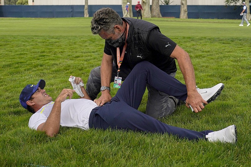 Brooks Koepka gets treated for an injury on the 12th hole during Friday's second round of the PGA Championship at TPC Harding Park in San Francisco.