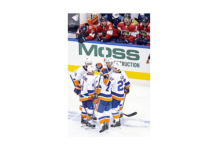 New York Islanders center Mathew Barzal (13) celebrates his goal with teammates as Florida Panthers players look on from the bench during the third period NHL Stanley Cup Playoff qualifying round hockey game in Toronto, Friday, Aug. 7, 2020. (Chris Young/The Canadian Press via AP)