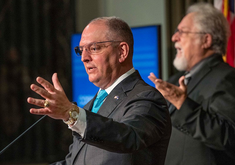 Louisiana Gov. John Bel Edwards makes a point while answering questions about the status of the state in regard to COVID-19, Thursday, Aug. 6, 2020, in Baton Rouge, La. The state will continue to be in Phase 2 until Aug. 28. Dr. Daniel Burch does sign language interpretation at right. (Bill Feig/The Advocate via AP)
