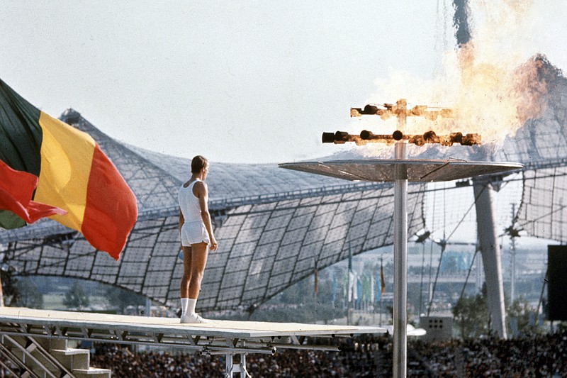 In this Aug. 26, 1972, file photo, West German middle distance runner, junior athlete Guenther Zahn stands near the Olympic flame he lit above the Olympic Stadium during the opening ceremony of the Summer Olympic Games in Munich, Germany.