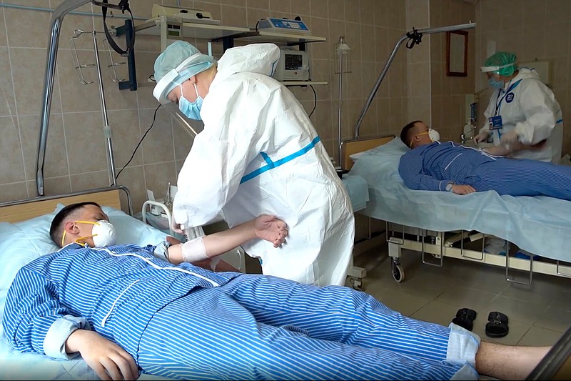 In this photo made from footage provided by the Russian Defense Ministry on Wednesday, July 15, 2020, medical workers in protective gear prepare to draw blood from volunteers participating in a trial of a coronavirus vaccine at the Budenko Main Military Hospital outside Moscow, Russia. Russia is boasting that it's about to be the first country to approve a COVID-19 vaccine, but scientists worldwide are sounding the alarm that the headlong rush could backfire. (Russian Defense Ministry Press Service via AP)