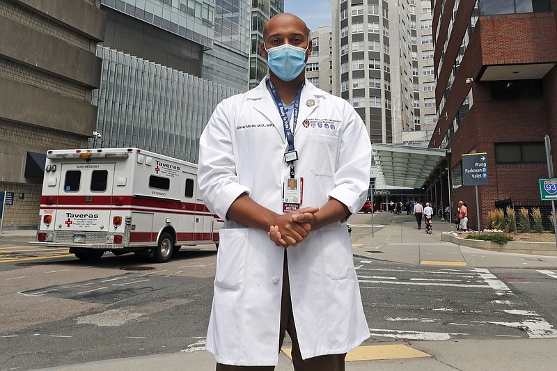 Alister Martin, an emergency room doctor at Massachusetts General Hospital, poses outside the hospital, Friday, Aug. 7, 2020, in Boston. Martin founded the organization "VotER" to provide medical professionals voter registration resources for patients who are unregistered voters. (AP Photo/Charles Krupa)