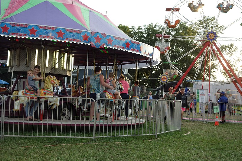 Children took turns going round and round on the carousel while friends and family either joined or watched from the gate at the 154th Moniteau County Fair.