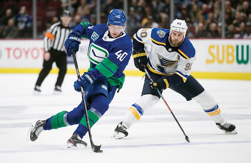 In this Nov. 5, 2019, file photo, Elias Pettersson of the Canucks skates with the puck while being watched by Ryan O'Reilly of the Blues during a game in Vancouver, British Columbia.