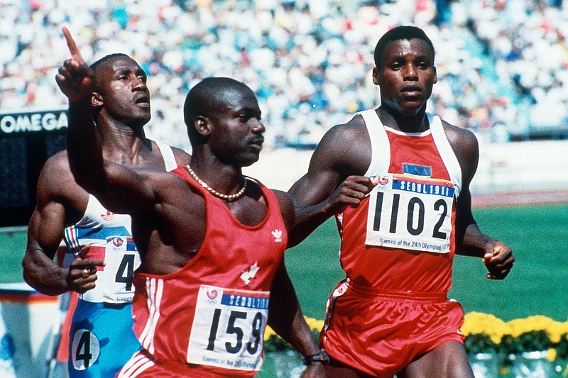 In this Sept. 25, 1988, file photo, Canadian Ben Johnson, left, signals victory ahead of the United States' Carl Lewis, as he wins the 100-meter final at the Summer Olympic Games in Seoul, South Korea. (AP Photo/Rick Wilking, File)