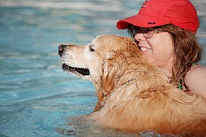 <p>Daisy, a 9-year-old golden retriever, stays close to her friend Debbie Marcell during a 2014 Hot Dippity Dog event. This year’s event is set for 6-7 p.m. Sunday at Memorial Park Aquatic Center. News Tribune file photo</p>
