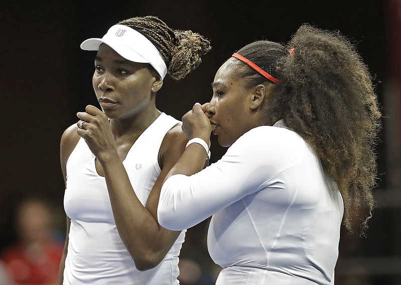 In this Feb. 11, 2018, file photo, Venus Williams (left) and Serena Williams talk between points in their doubles match against Netherlands in the first round of Fed Cup in Asheville, N.C.