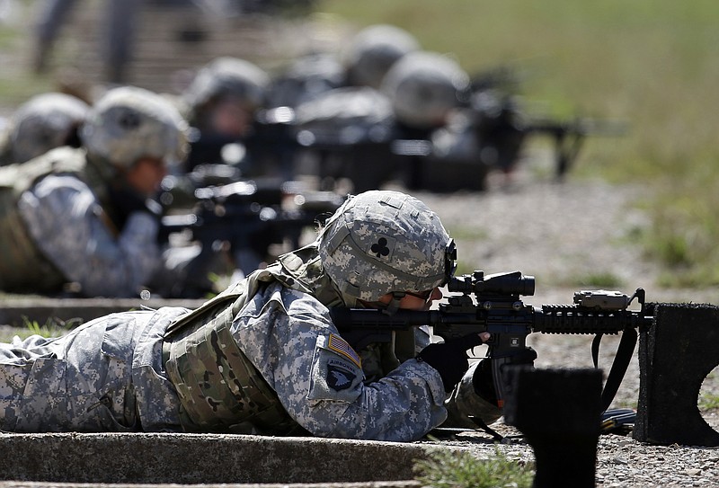 FILE - In this Sept. 18, 2012 file photo, female soldiers from 1st Brigade Combat Team, 101st Airborne Division train on a firing range while testing new body armor in Fort Campbell, Ky.  A federal appeals court in New Orleans upheld the constitutionality of the all-male military draft system Thursday, Aug. 13, 2020, citing a 1981 U.S. Supreme Court decision.The 5th U.S. Circuit Court of Appeals in New Orleans said “only the Supreme Court may revise its precedent.”  (AP Photo/Mark Humphrey, File)