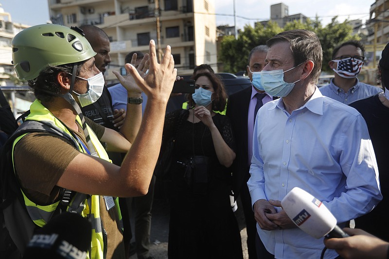 U.S. Undersecretary of State for Political Affairs David Hale, right, listens to an NGO volunteer during his visit to a main gathering point for volunteers, near the site of last week's explosion that hit the seaport of Beirut, Lebanon, Thursday, Aug. 13, 2020. (AP Photo/Hussein Malla, Pool)