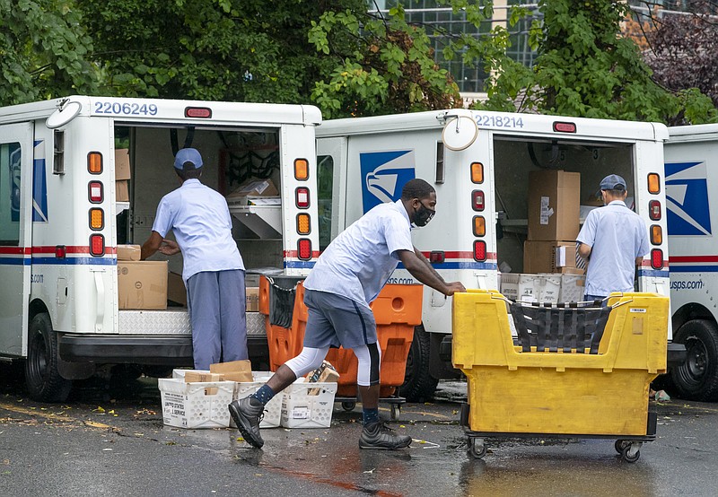 FILE - In this July 31, 2020, file photo, letter carriers load mail trucks for deliveries at a U.S. Postal Service facility in McLean, Va. The success of the 2020 presidential election could come down to a most unlikely government agency: the U.S. Postal Service.  (AP Photo/J. Scott Applewhite, File)