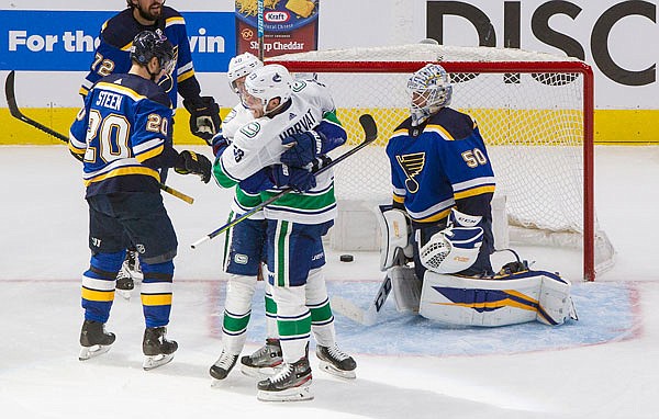 Canucks teammates Bo Horvat and Elias Pettersson celebrate a goal against Blues goalie Jordan Binnington as Alexander Steen of the Blues reacts during Friday's game in Edmonton, Alberta.