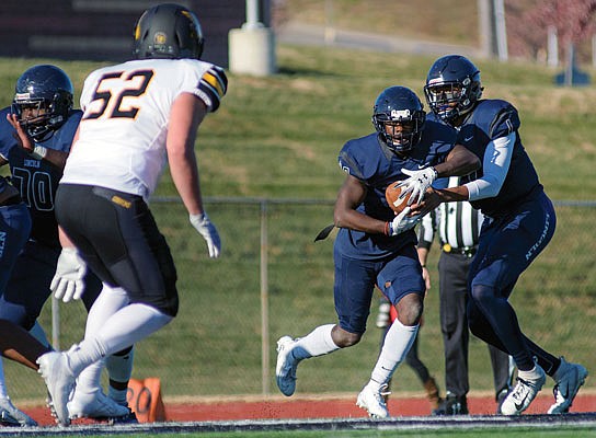Lincoln quarterback Chancellor Johnson reads the Western Missouri defense and pulls the handoff from running back Michael Jones, Jr., before scrambling for yardage during a game last season at Dwight T. Reed Stadium.