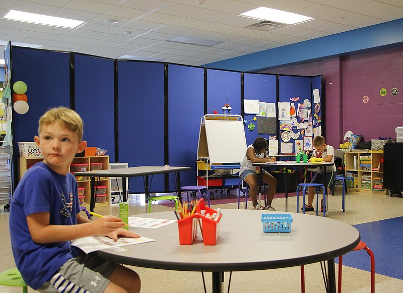 Kids decorate coloring sheets and watch television in one of the classrooms at the Boys and Girls Club of Jefferson City on Aug. 5, 2020. Behind them is one of the club's large blue room partitions; about seven or eight kids were on one side, and about the same amount were on the other.