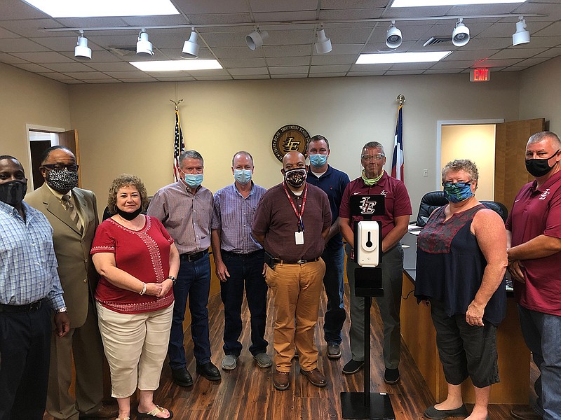 Four Career Tech Education staff members were recognized Thursday night at the Liberty-Eylau school board meeting for welding 30 hand-sanitizing stands from scratch. The four are surrounded by school board members, school board president and the superintendent. They are, from left, president Trevelyan Hodge, trustee James Keeton, trustee Becky Fellers, Ray Howell (welding), Rodney Fellers (Auto Tech), Daniel Mitchell (Auto Body), Bryan Scheu (Welding), superintendent Ronnie Thompson, trustee Debby Courtney and trustee Chad Turner.  (Photo courtesy of Matt Fry, LE-ISD director of communications)
