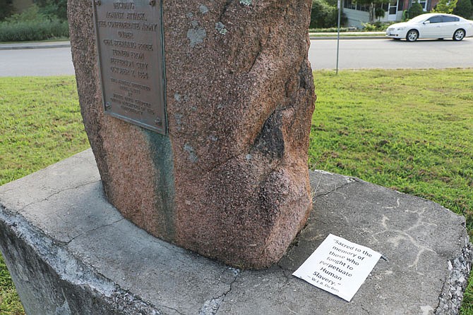 A message on a sheet of white paper is seen at the foot of the Sterling Price marker along Moreau Drive, which on Aug. 22 read "Sacred to the memory of those who fought to perpetuate human slavery." The quote was written by W.E.B. Du Bois in a 1931 in reference to what Du Bois thought inscriptions on Confederate monuments should read. 