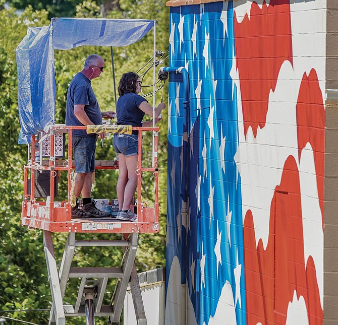 Julianne Lough and her grandfather, Ray Harvey, have been working to paint a mural on the exterior of the south end of American Legion Post 5 on Tanner Bridge Road. The building is undergoing remodeling during which the decision was made to make a change. The painters had a good work week, weather-wise, to get this 24-by-36-foot wall covered to look like a large American flag waving in the wind.