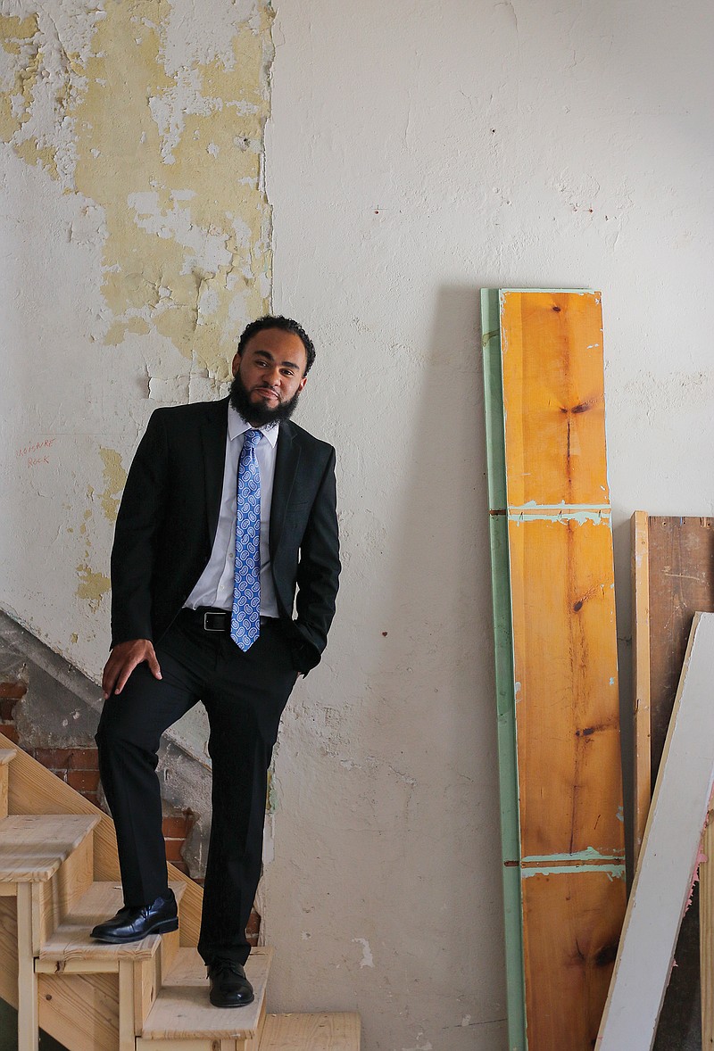 Spencer Hoogveld stands for a portrait July 14 on the stairs inside the small building at 224 E. Dunklin St. Hoogveld purchased the historic home, which was built in 1910, to renovate and lease as a commercial space with an apartment on the second floor. Hoogveld said he and his crew expected the renovation to take about three months.