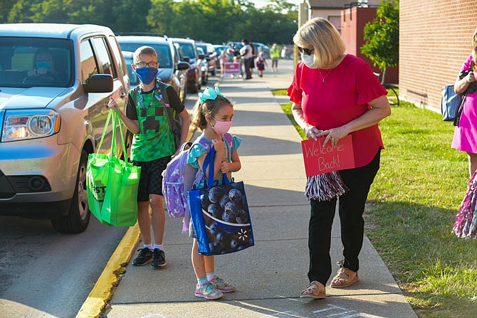 Missouri first lady Teresa Parson, at right, walks with students, including first-grader Rena Miller and third-grader Andrew Raley, as they prepare to enter the building at Lawson Elementary School. Monday was the first day of class in the Jefferson City School District. Parson was joined by Mayor Carrie Tergin on the first day to greet and welcome students to a new school year.