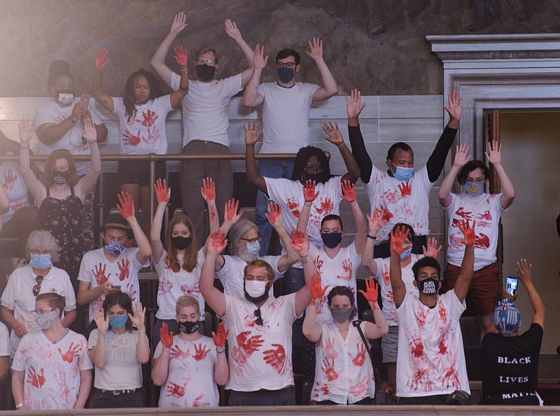 Members of ExpectUs hold up their hands, showing red stains to represent the blood they believe Missouri lawmakers have on their hands after passing bills intended to curb violence Tuesday, Aug. 25, 2020. Protesters said the bills do the opposite and are being used for political gain.