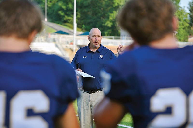 Helias coach Chris Hentges addresses his players earlier this month at Ray Hentges Stadium.