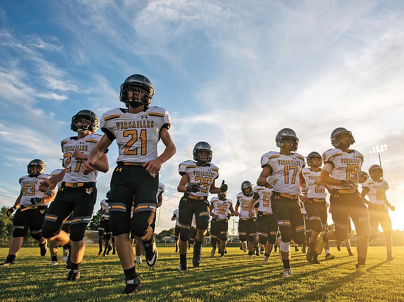 The Versailles Tigers run onto the field prior to a game last season against the Southern Boone Eagles in Ashland.