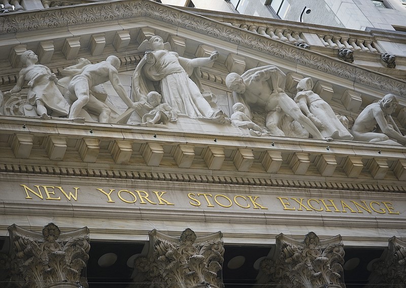 FILE - Marble sculptures occupy the pediment above the New York Stock Exchange signage, Tuesday Aug. 25, 2020, in New York.  Stocks are pushing further into record heights on Wall Street Thursday, after the Federal Reserve made a major overhaul to its strategy, one that could keep interest rates lower for longer.  (AP Photo/Bebeto Matthews)