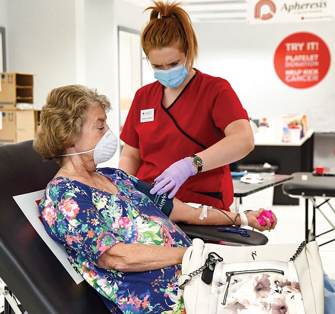 FILE: Doris Broeker, left, wears a mask June 15, 2020, for safety, as does phlebotomist Kristen Holland, at the Jefferson City blood center of  the American Red Cross. 