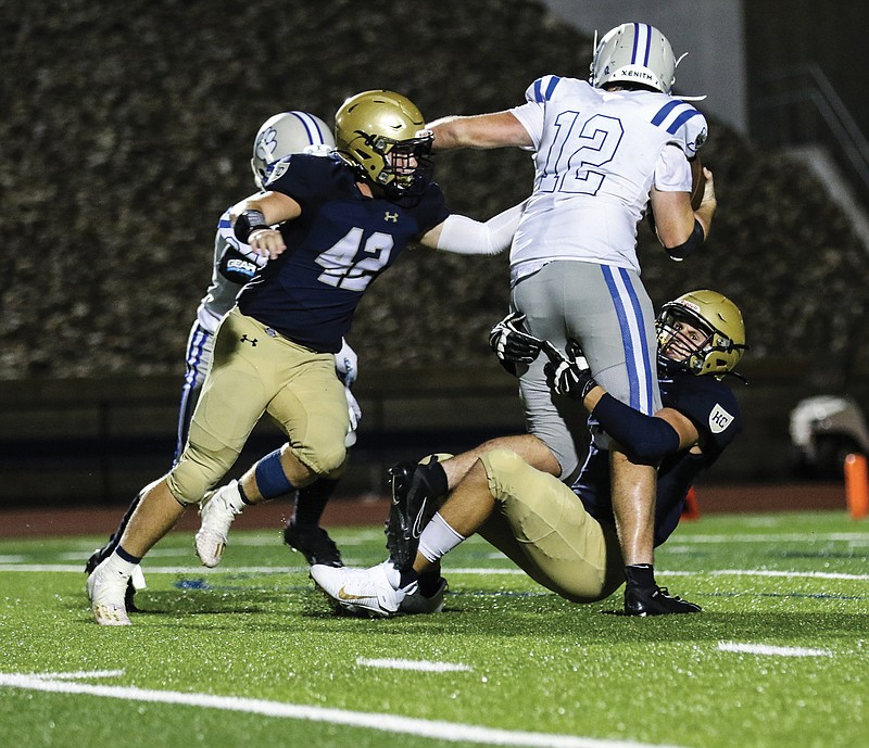 Helias defensive end Damon Johanns sacks Lutheran: St. Charles quarterback Aaron Coffey as Helias linebacker Ethan Holzhauser comes in to finish off the tackle during Friday night's game at Ray Hentges Stadium.