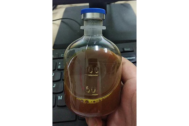A Uighur under quarantine shows a bottle of unidentified traditional Chinese medicine in Urumqi, China. As parts of the Xinjiang region in China's far northwest enters the 45th day of a second grueling lockdown due to a coronavirus outbreak, the government there is coercing some residents into using traditional Chinese medicine despite a lack of rigorous clinical data proving it works. 
