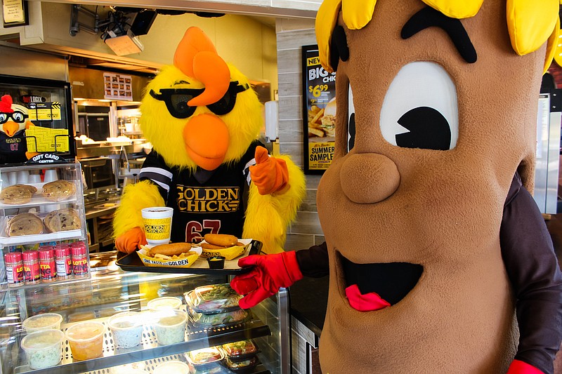 Golden Chick restaurants mascot Clucky, left, and Fletcher's Original Corny Dogs mascot Mr. Corny pose for a photo to promote a limited-time partnership between the two Texas-based brands. Because the State Fair of Texas has been canceled due to the coronavirus pandemic, Fletcher's, which normally sells about 500,000 corny dogs each year at the fair, has partnered with Golden Chick to offer them at 187 of its restaurants throughout Texas, Oklahoma and Louisiana. The offer will end Oct. 25.