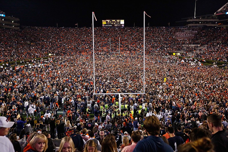 Fans rush the field after Auburn defeated Alabama in the Iron Bowl NCAA college football game, Saturday, Nov. 25, 2017, in Auburn, Ala. What is most commonly referred to as major college football (aka NCAA Division I Bowl Subdivision or FBS) is compromised of 130 teams and 10 conferences. Seventy-seven of those teams are scheduled to play throughout the fall, starting at various times in September. The other 53, including the entire Big Ten and Pac-12, have postponed their seasons and are hoping to make them up later. That means no No. 2 Ohio State, No. 7 Penn State, No. 9 Oregon and six other teams that were ranked in the preseason AP Top 25. (AP Photo/Brynn Anderson, File)