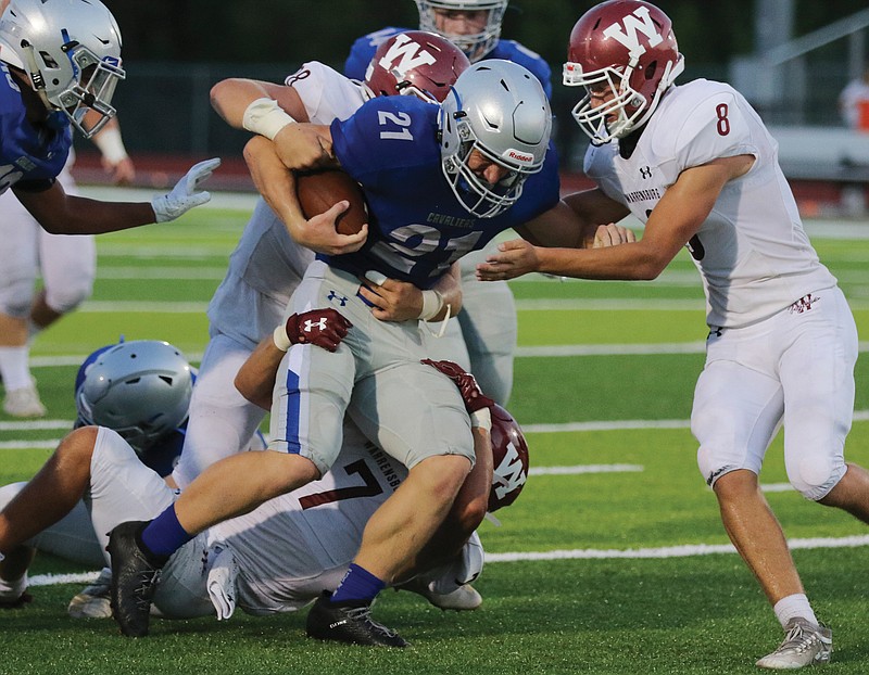 Capital City running back Ethan Wood tries to break free from the Warrensburg defense during last Friday night's game at Adkins Stadium.