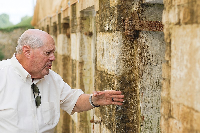 Mark Schreiber looks inside one of the Centennial Cells and recounts some of their history Thursday during a tour. The cells and believed to have been part of Centennial Hall, which is no longer standing, and built in the mid-1800s or so.