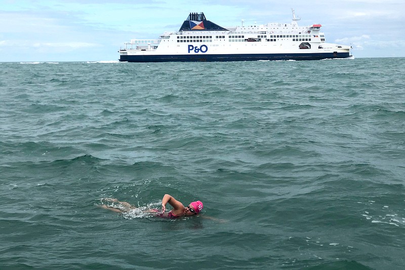 In this photo provided by Darcie DeBlois-Rivard, long distance swimmer Vera Rivard, 16, of Springfield, N.H., below, swims the English Channel between Dover, England and Calais, France, as a channel ferry sails by, above, Tuesday, Sept. 1, 2020. The swim took her more than 14 hours, and she is the second American to cross the channel this year. (Photo Darcie DeBlois-Rivard via AP)