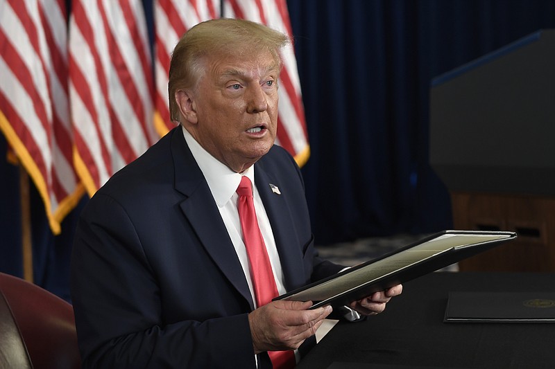 FILE - In this Saturday, Aug. 8, 2020, file photo, President Donald Trump prepares to sign four executive orders during a news conference at the Trump National Golf Club in Bedminster, N.J. As employees of small businesses get their first September paychecks, they’re probably receiving their usual amount, as company owners are still withholding money for Social Security despite a presidential order allowing the tax to be deferred. (AP Photo/Susan Walsh, File)