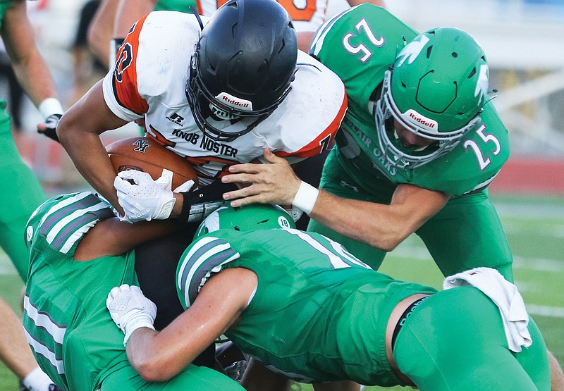 Knob Noster running back Tim Williams is tackled by Blair Oaks defensive players Levi Haney (25), Ian Nolph (18) and Cobi Marble (11) during Friday night's game at the Falcon Athletic Complex in Wardsville.
