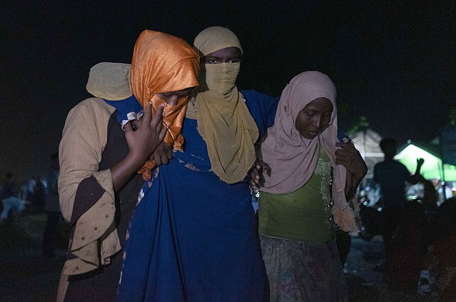  An ethnic Rohingya woman is assisted by others early Monday after the boat carrying them landed in Lhokseumawe, Aceh province, Indonesia.
