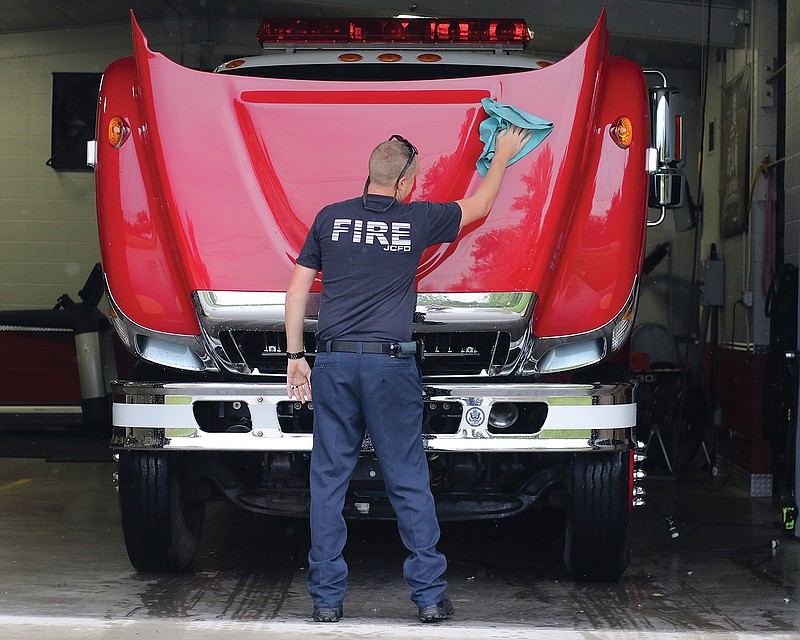 Jefferson City firefighter Jesse Berendzen wipes off a Station 4 fire engine Tuesday, Sept. 8, 2020, after it came back from maintenance work. 