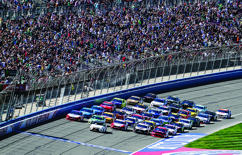 In this March 17, 2019, file photo, NASCAR Cup Series cars line up five wide in a salute to fans during pace laps at Auto Club Speedway, in Fontana, Calif.