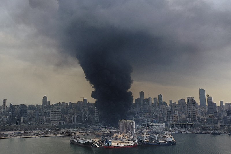 Black smoke rises from a fire at warehouses at the seaport of Beirut, Lebanon, Thursday, Sept. 10. 2020. A huge fire broke out Thursday at the Port of Beirut, triggering panic among residents traumatized by last month's massive explosion that killed and injured thousands of people. (AP Photo/Hussein Malla)