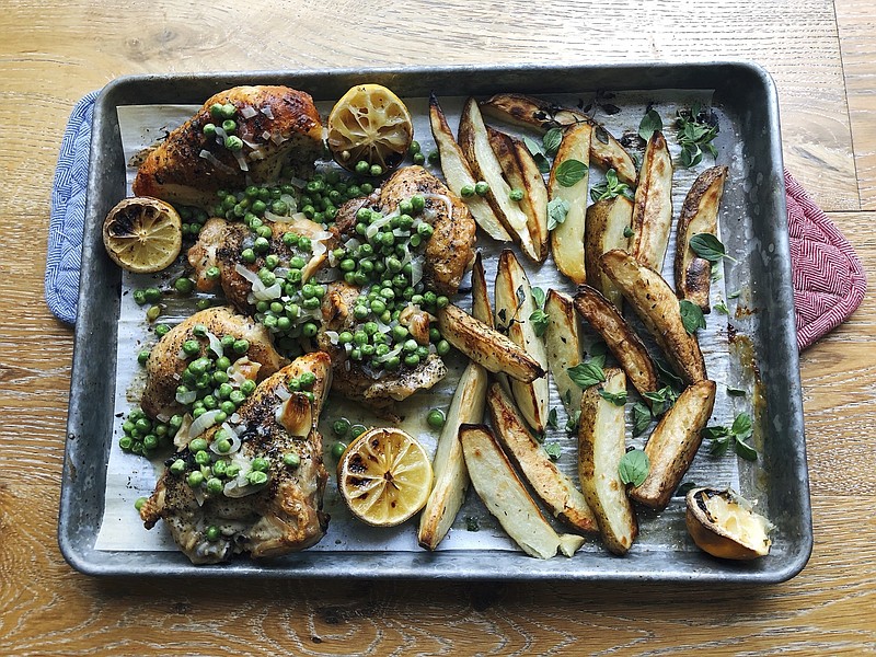 This image taken Sept. 6, 2020 in Alexandria, Va., shows a recipe for roasted chicken, potato wedges and green peas prepared in a sheet pan. This easy-to-prep, easy-to-cook, easy-to-clean, all-in-one-pan method can be applied to lots of different dinners. (Elizabeth Karmel via AP)
