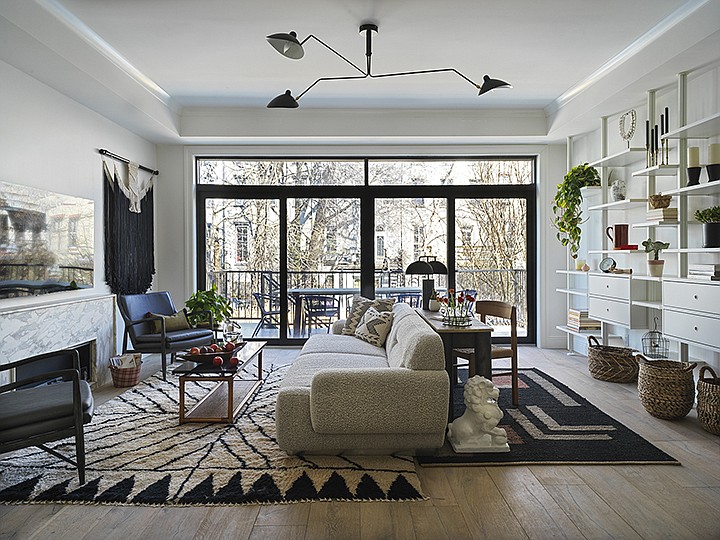 This photo provided by interior designer Jenny Dina Kirschner shows the living room of an apartment in the Brooklyn borough of New York. To create an additional home workspace within this living room, Kirschner placed a desk behind the sofa to create a work area that offers natural light and a convenient mix of open and closed storage along the back wall.