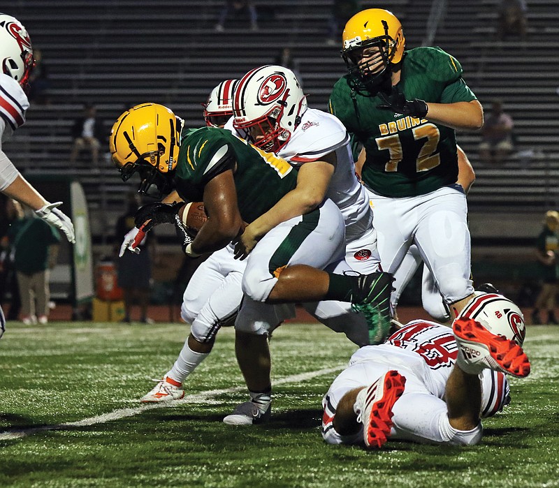 Jefferson City defensive lineman Jackson Figo wraps up Rock Bridge running back Bryce Jackson during Friday night's game in Columbia.